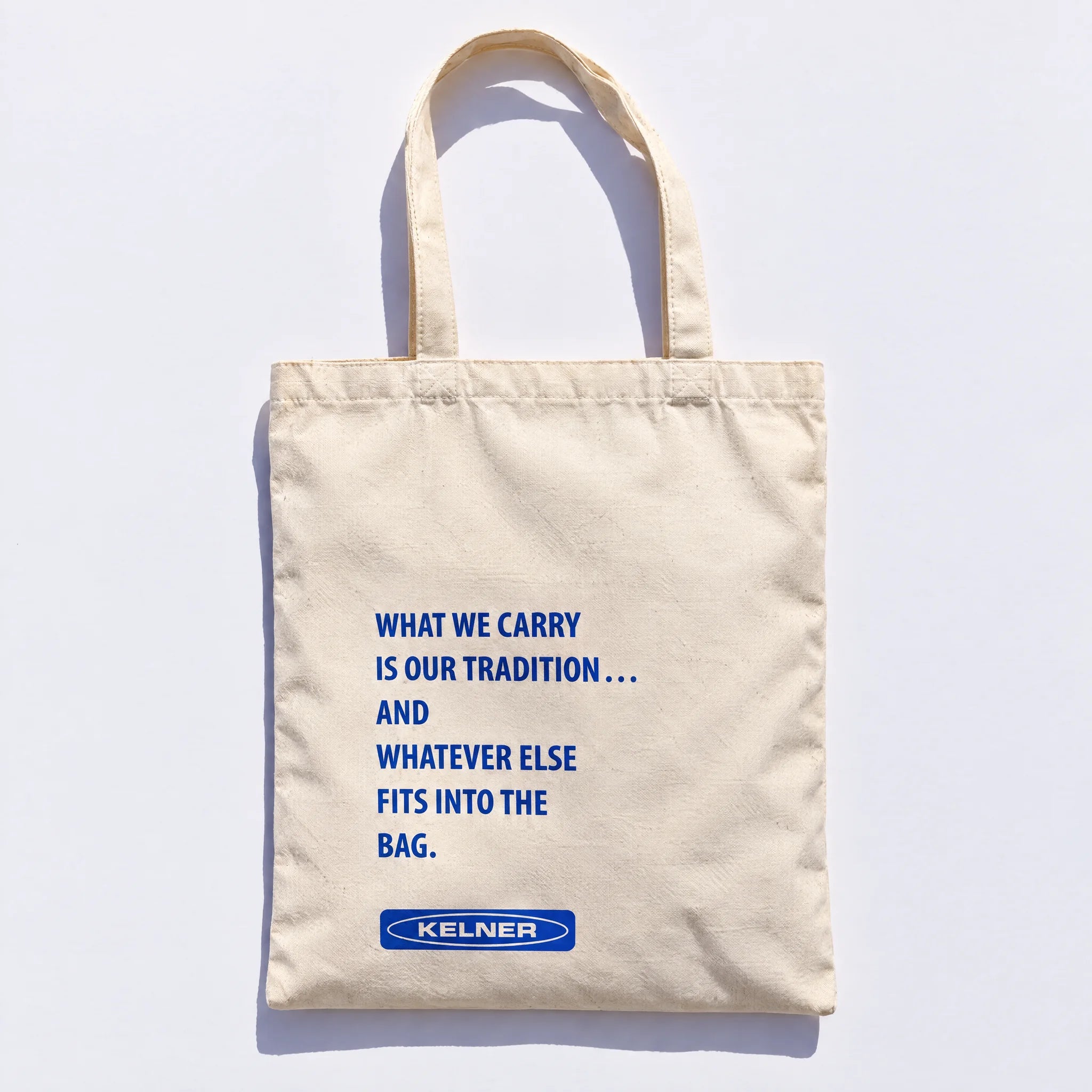 Back of the tote with its cobalt What We Carry statement and KELNER mark